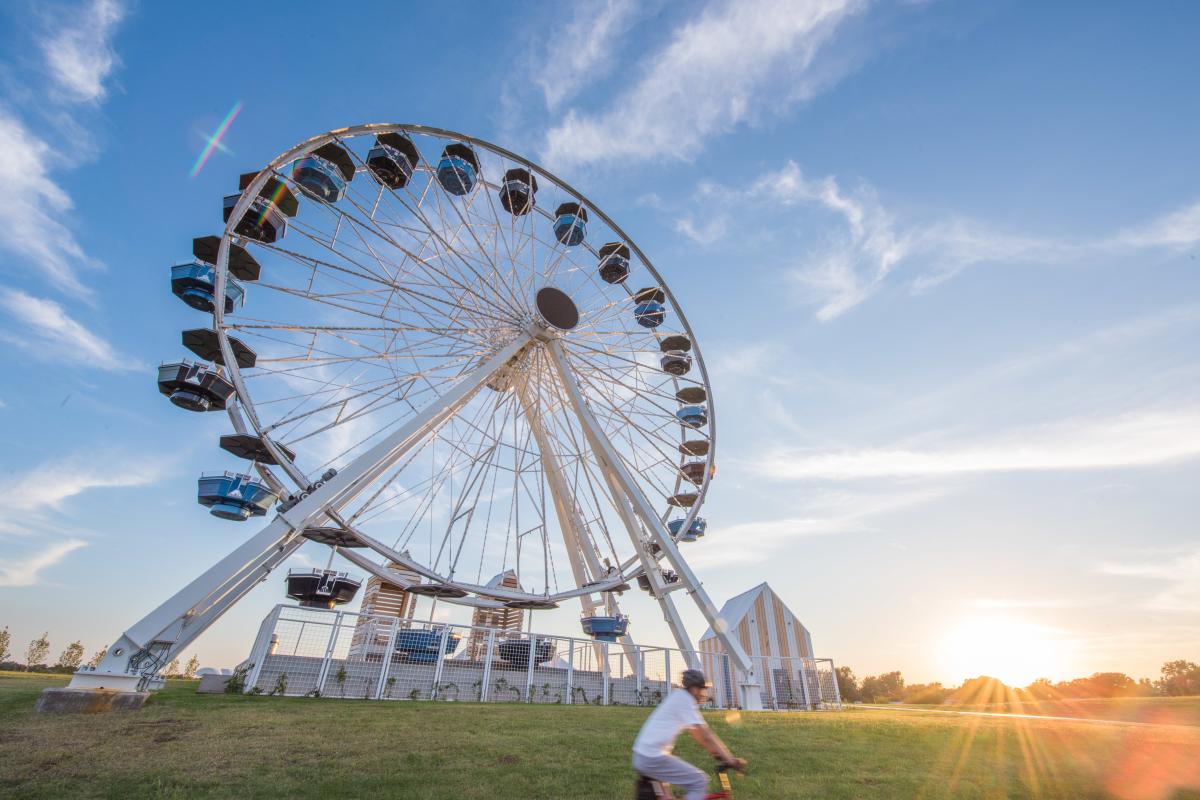 Outside shot of Wheeler Ferris Wheel with person on bike riding by