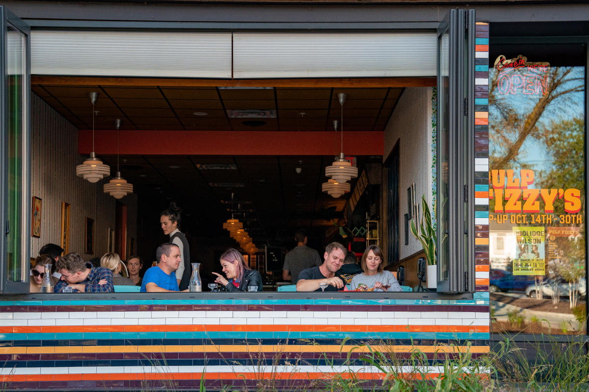 People sitting by an open window at Fizzy's.