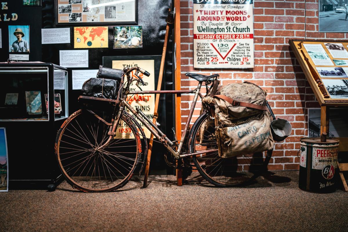 Museum display with Douglas Carr's bicycle and packs