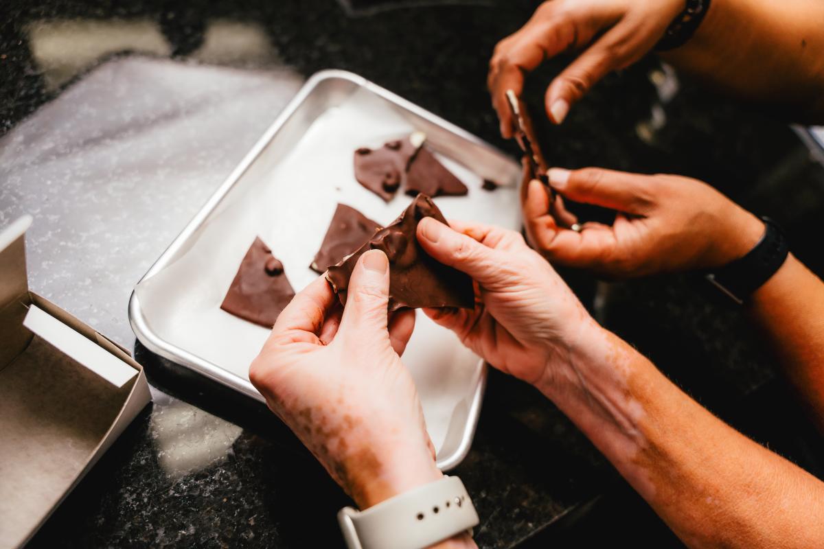 Hands breaking up the chocolate bark into pieces