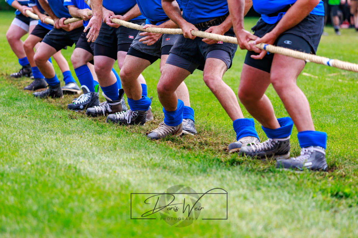 A team in matching blue pulls on the rope in a tug-of-war