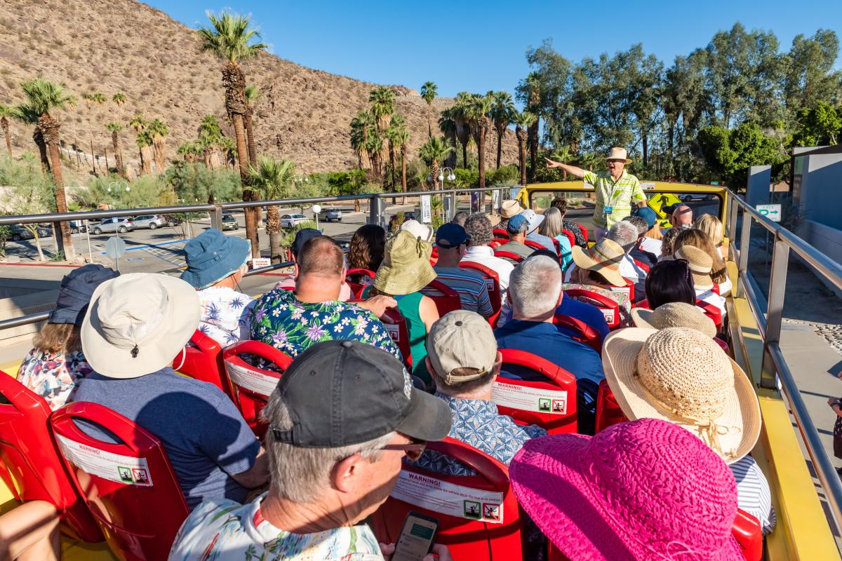 A Charles Phoenix led bus tour during Modernism Week with lots of people atop a double decker bus.