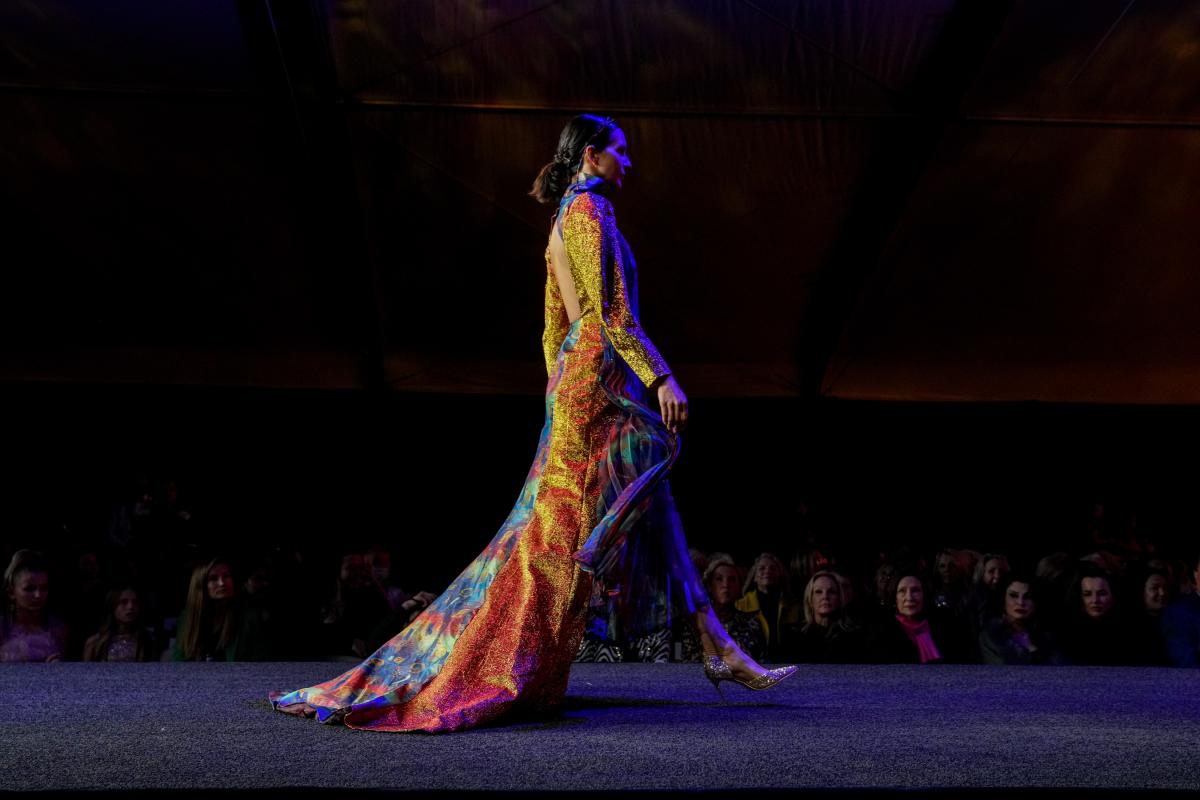A model wearing a long dress walks down the runway during Fashion Week El Paseo 2023.