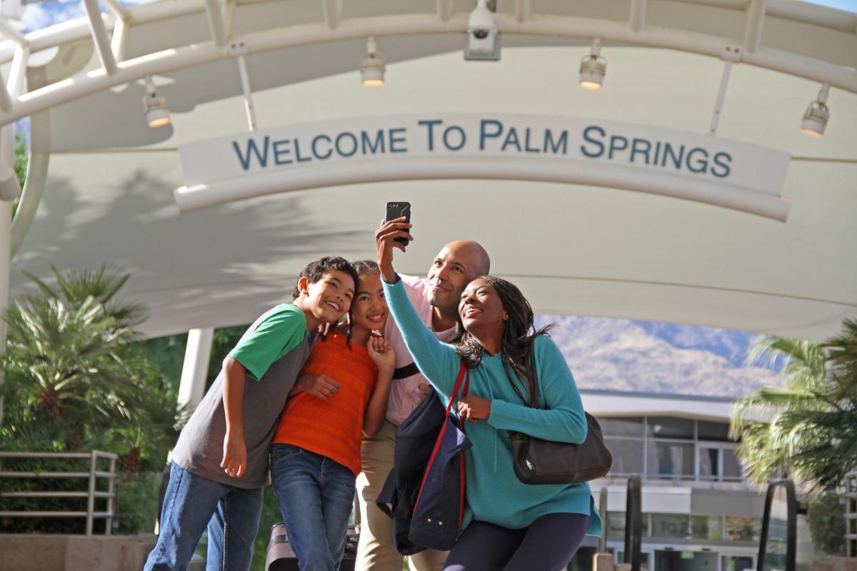 Family gathering to take a selfie infront of the Welcome to Palm Springs sign