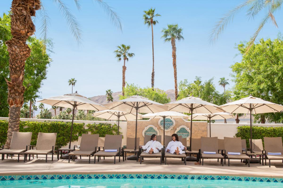 Two woman laying by the pool at Omni Rancho Mirage.