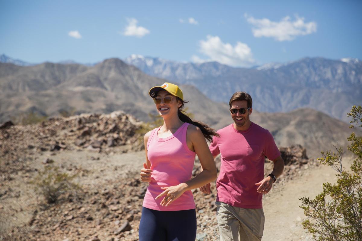 A couple wearing pink is hiking in the desert mountains