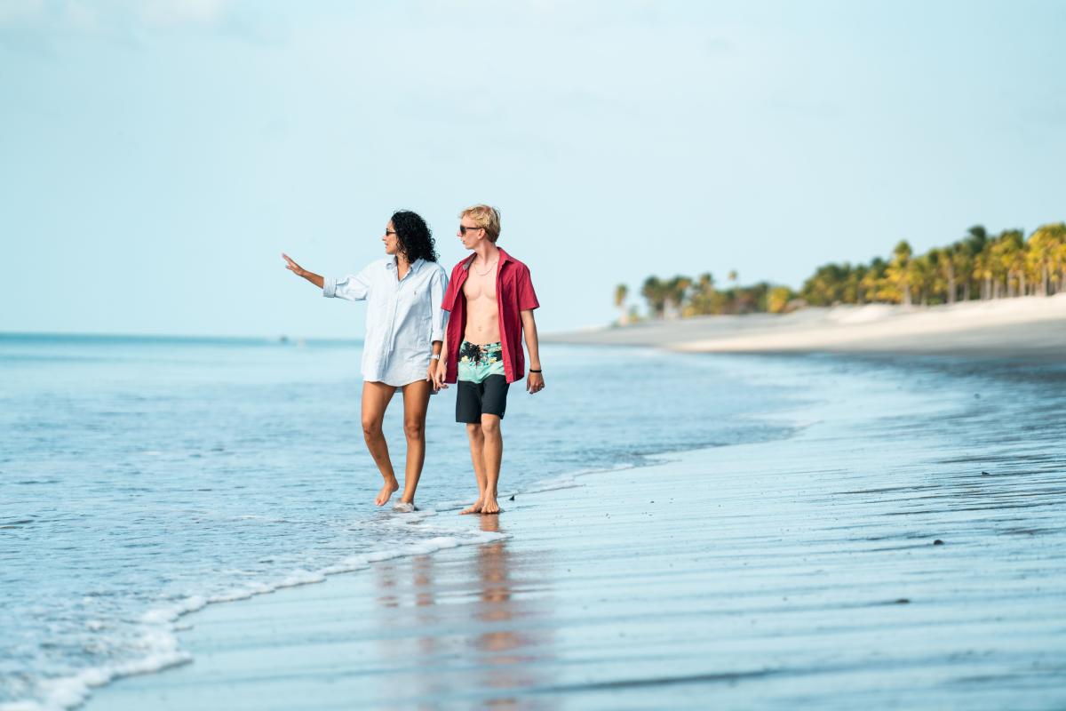 Friends leisurely walk along the sandy beach of Buenaventura