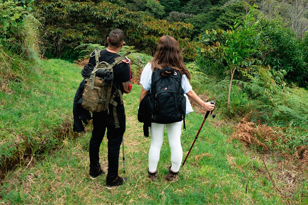 Casal fazendo trilha entre plantações de café em Tierras Altas, Panamá