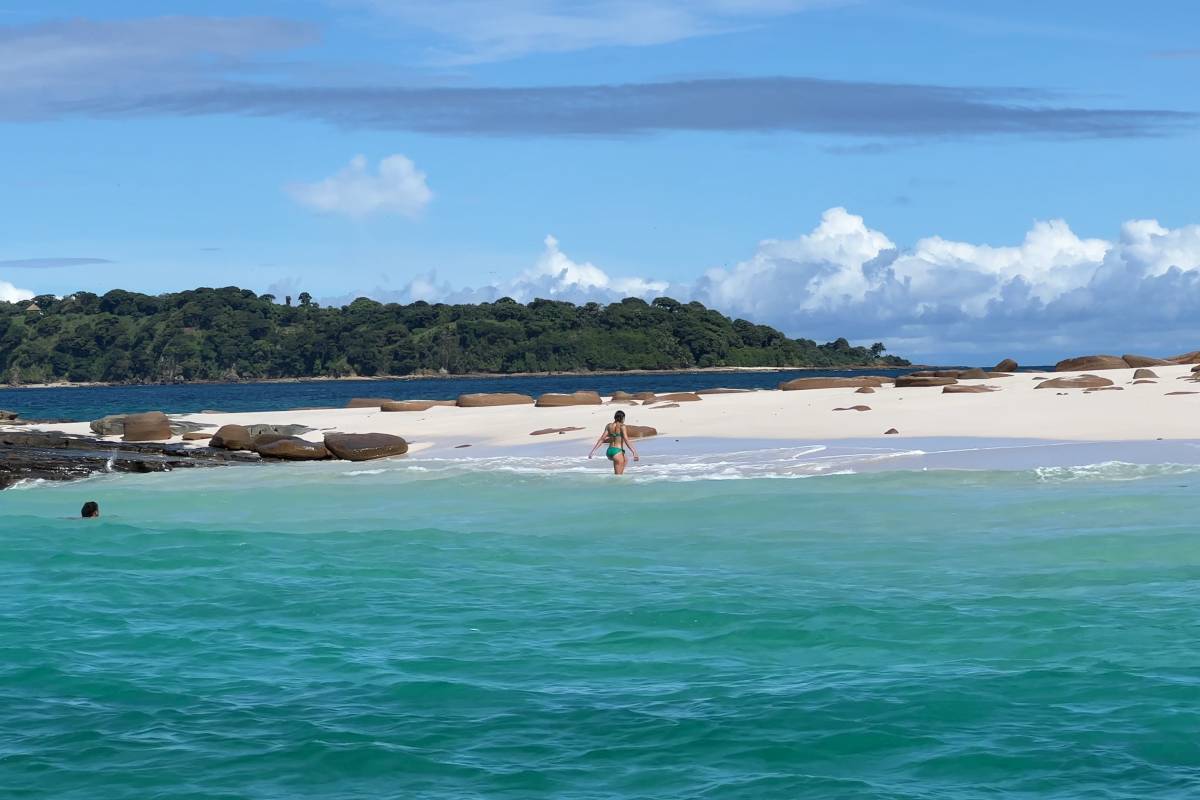 Woman walking along the beautiful sunny beach of Bartolome Island, Pearl Islands Panama City, Panamá