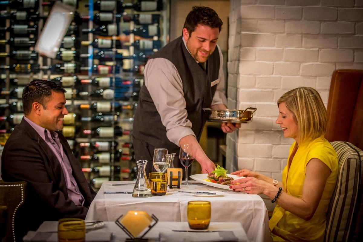 Dinner being served by waiter for the couple dining
