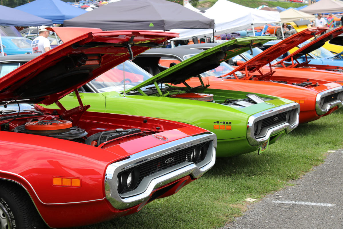 vintage Chryslers parked in row with hood popped for exhibit