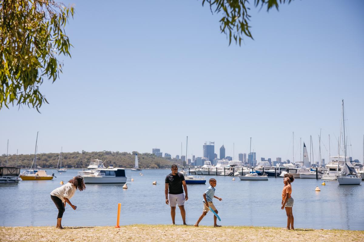 Family playing on the beach at the Swan River in Perth City