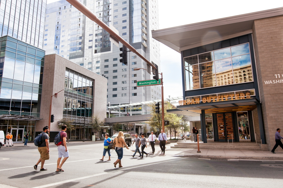 People walk down the street in downtown Phoenix's CityScape area.
