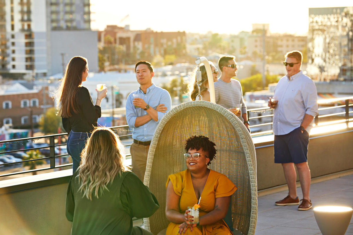 People talking and enjoying drinks at From the Rooftop at Hotel Cambria in downtown Phoenix's Roosevelt Row.