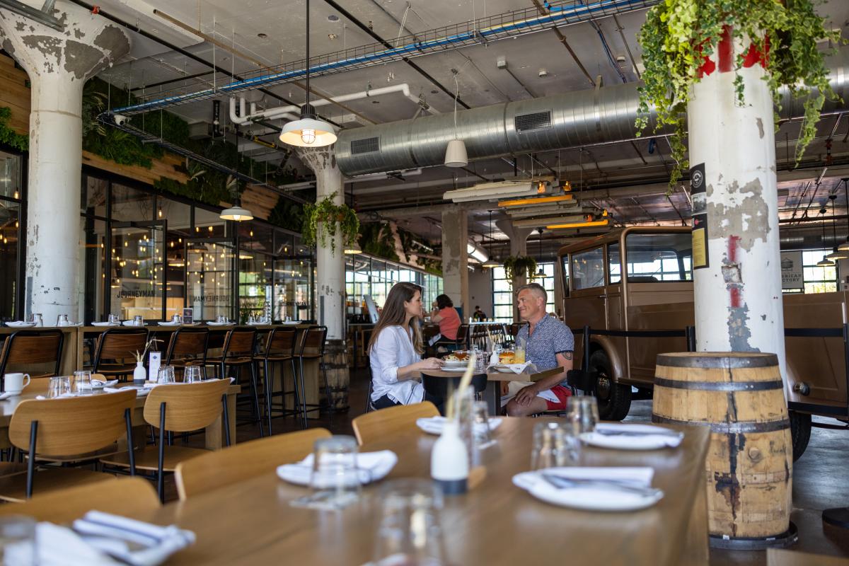 A couple sits at a restaurant table in a large space