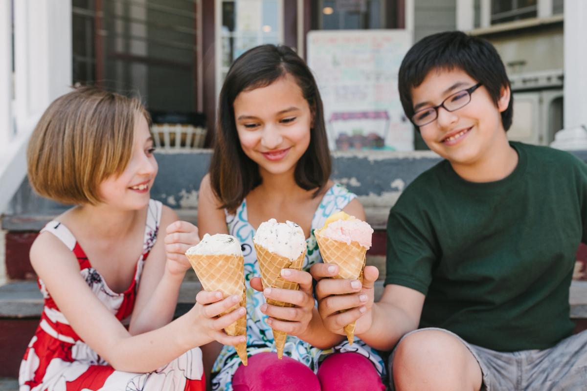 Three children holding ice cream in cones