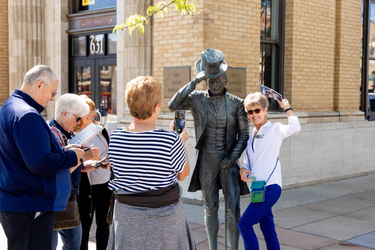 group posing with james monroe city of president statue in rapid city, sd