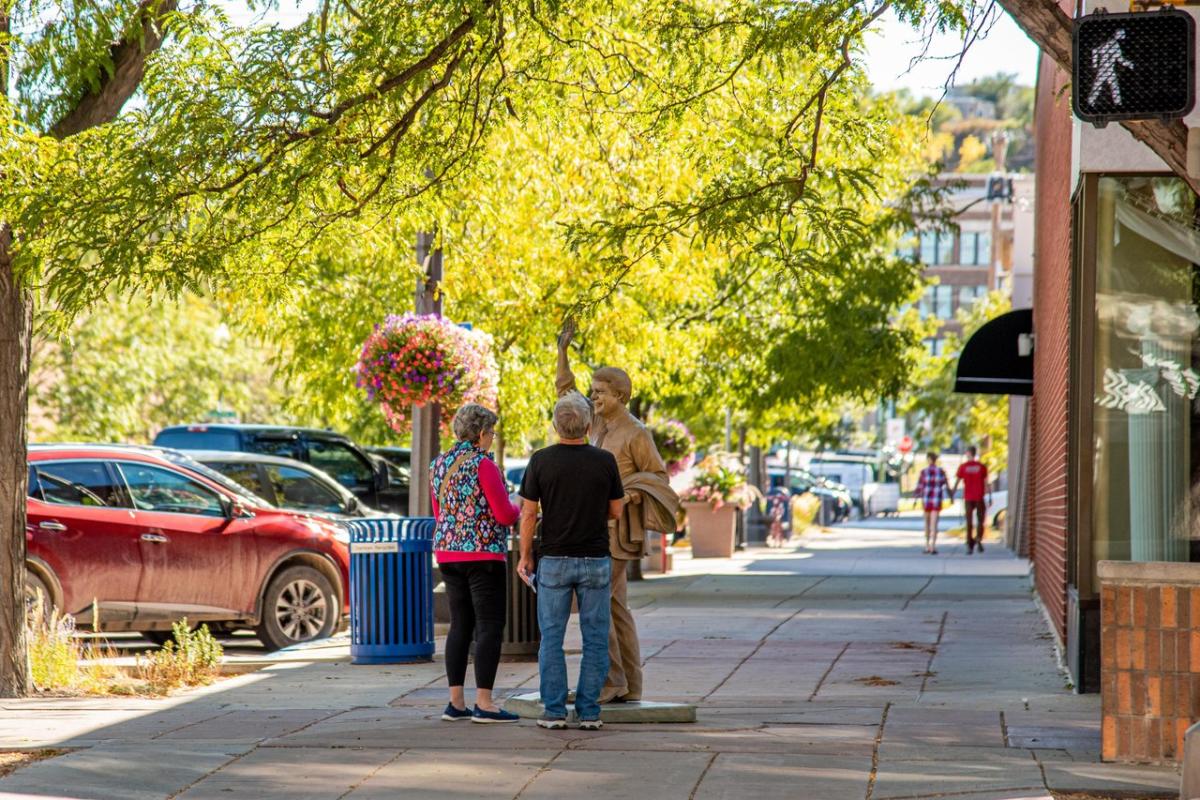 Man and women standing next to Jimmy Carter statue in the spring in the City of Presidents in downtown Rapid City
