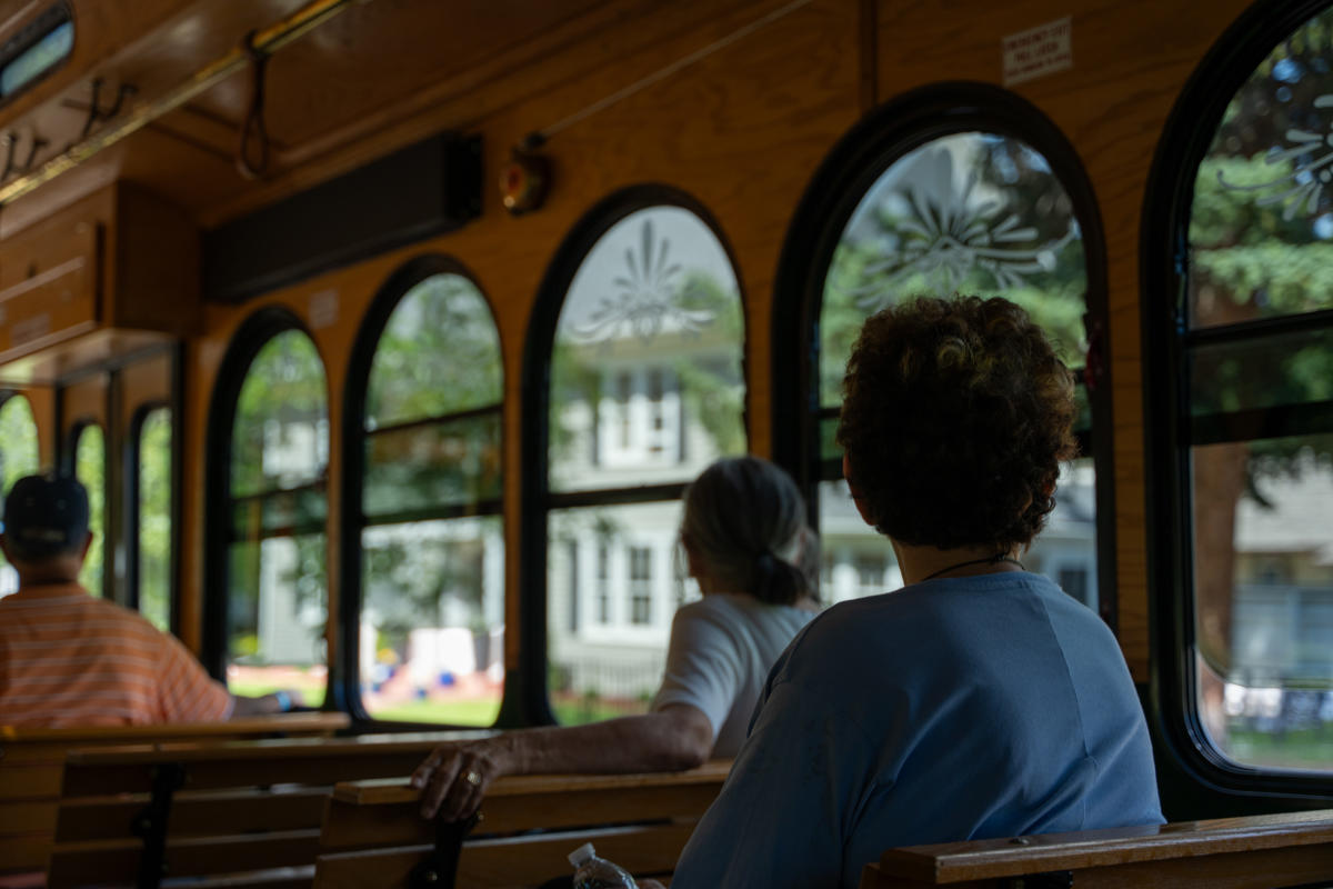 Trolley riders gaze out the windows of the City View Trolley at historic houses along the West Boulevard Historic District.