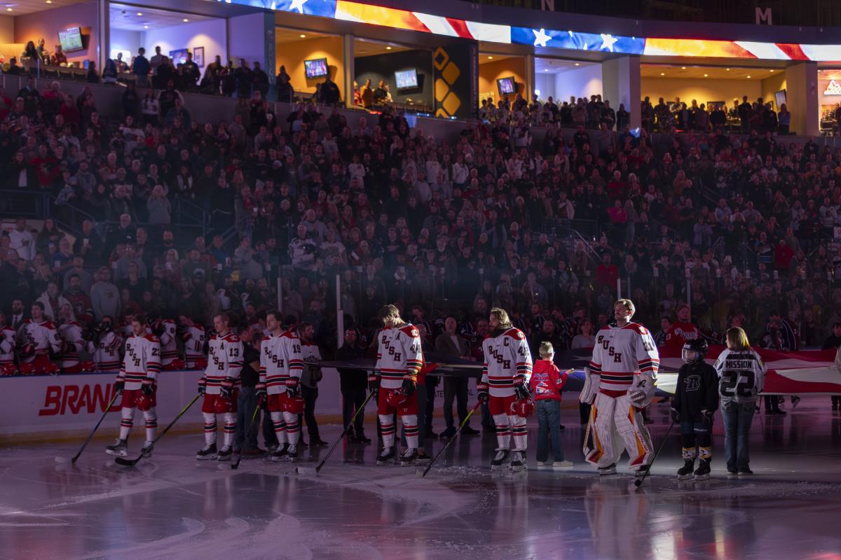Rush hockey game with players on the ice and flag behind them in rapid city sd