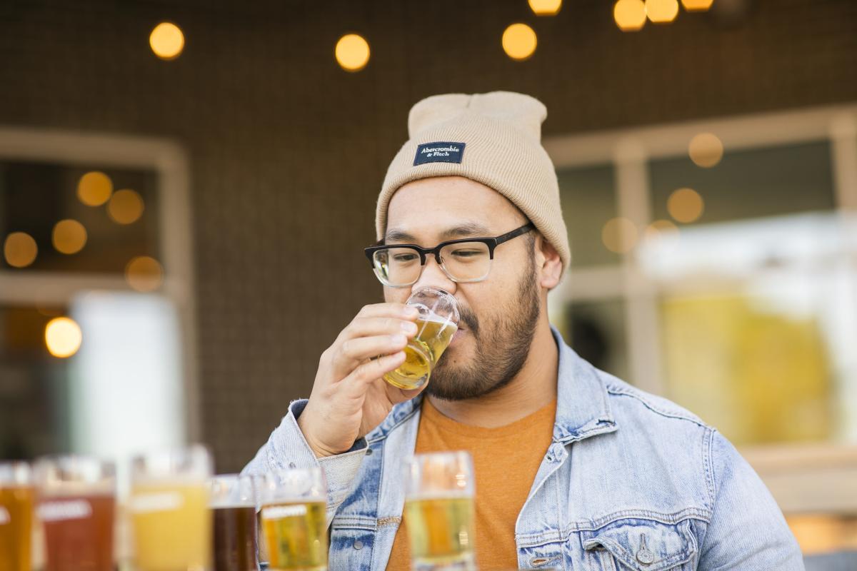 Man sipping locally brewed beer on an outdoor patio