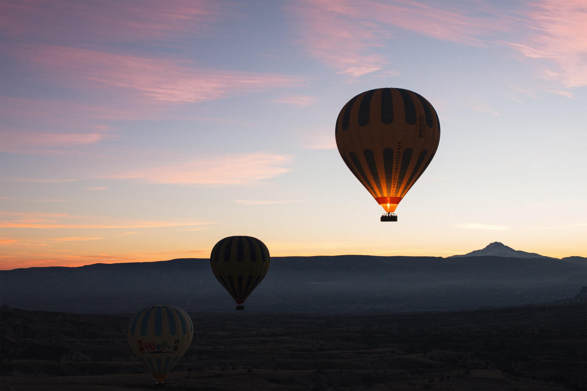 Three hot air balloons at sunrise in the sky over Perris, CA