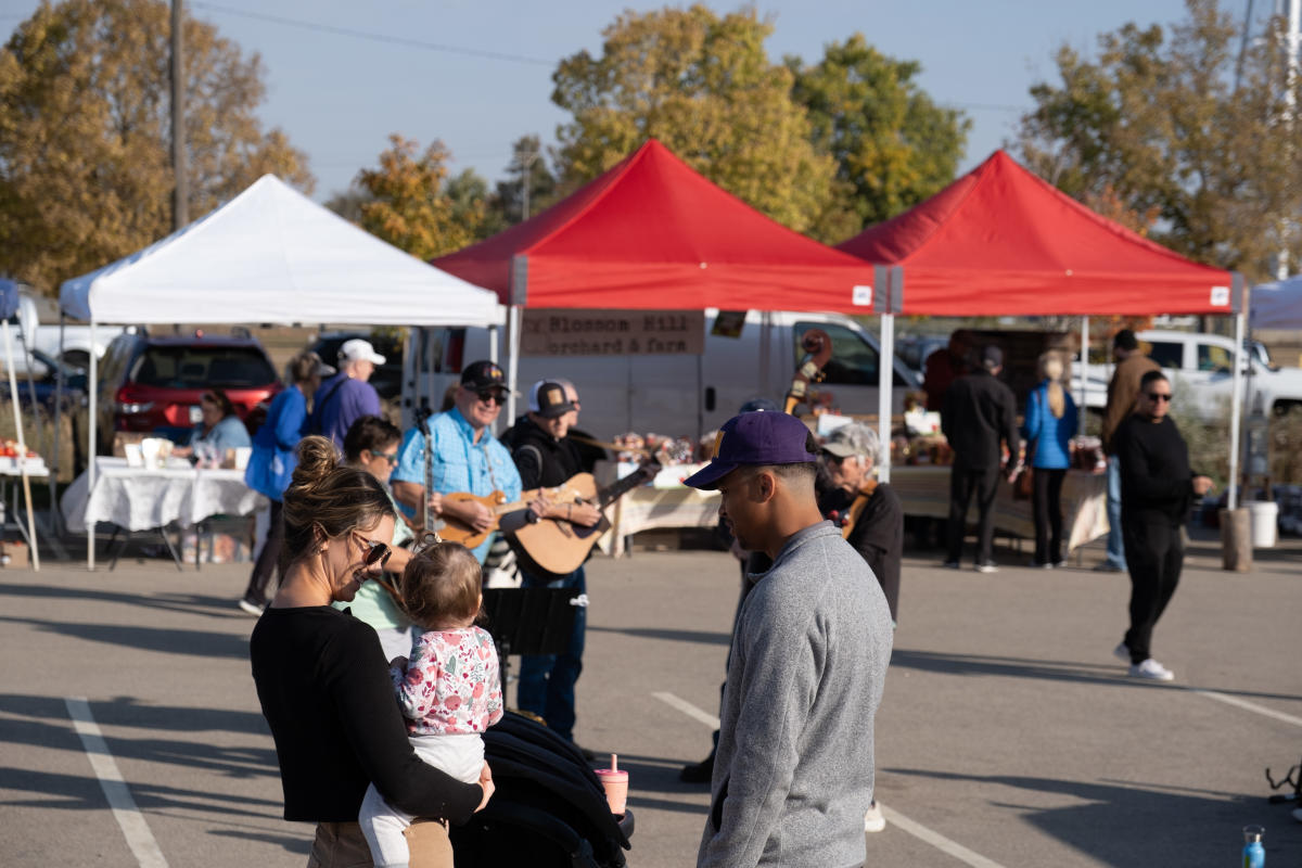 Family listening to live music at the Rochester Farmers Market