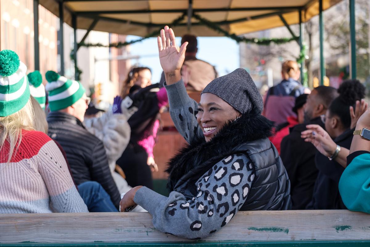 Woman waving from Horse and Wagon at 2022 Stroll on Start parade