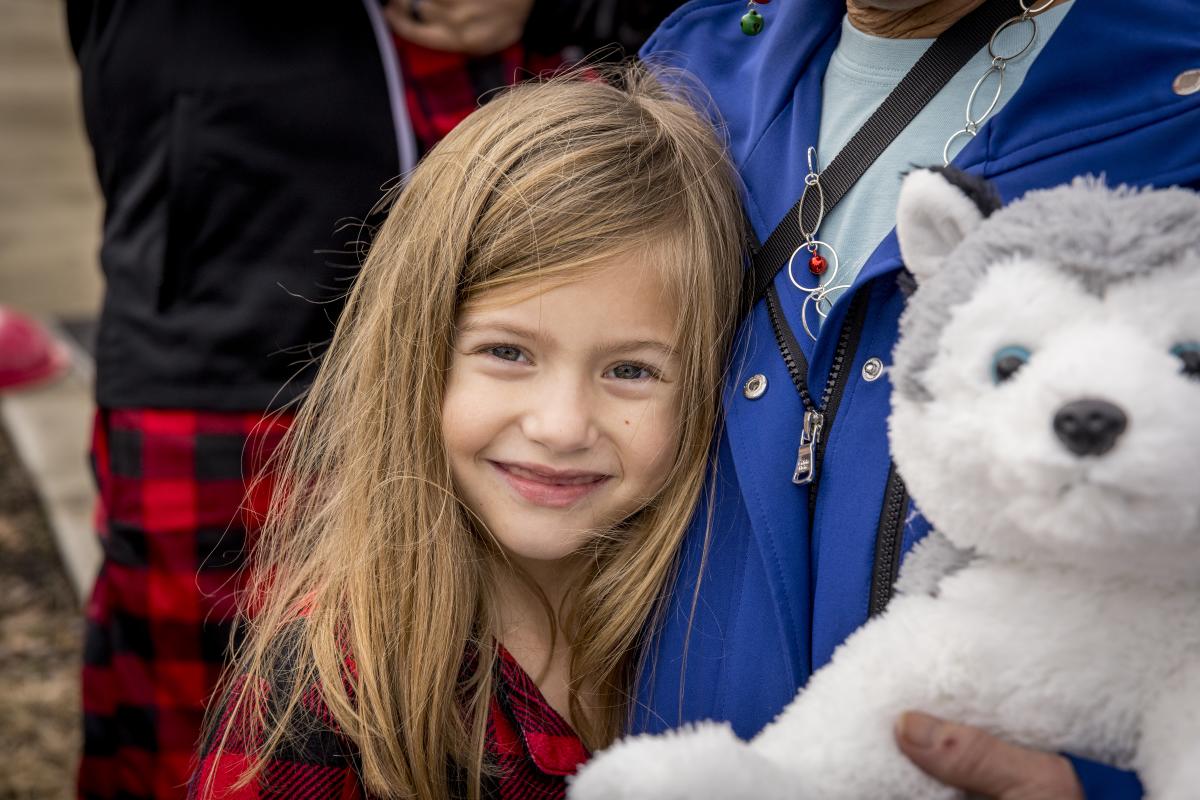 Girl holding stuffed dog at Christmas event