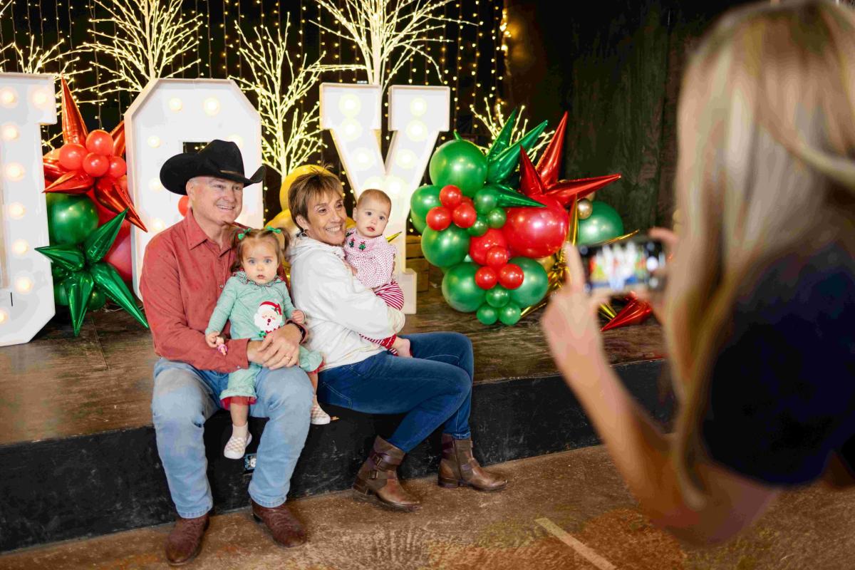 Man and woman holding two children taking a photo