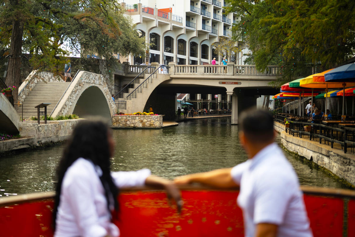 Couple on river barge facing bridge on River Walk