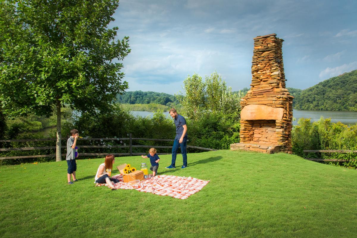 A Family having a picnic on the grass at Morgan Falls Overlook Park.