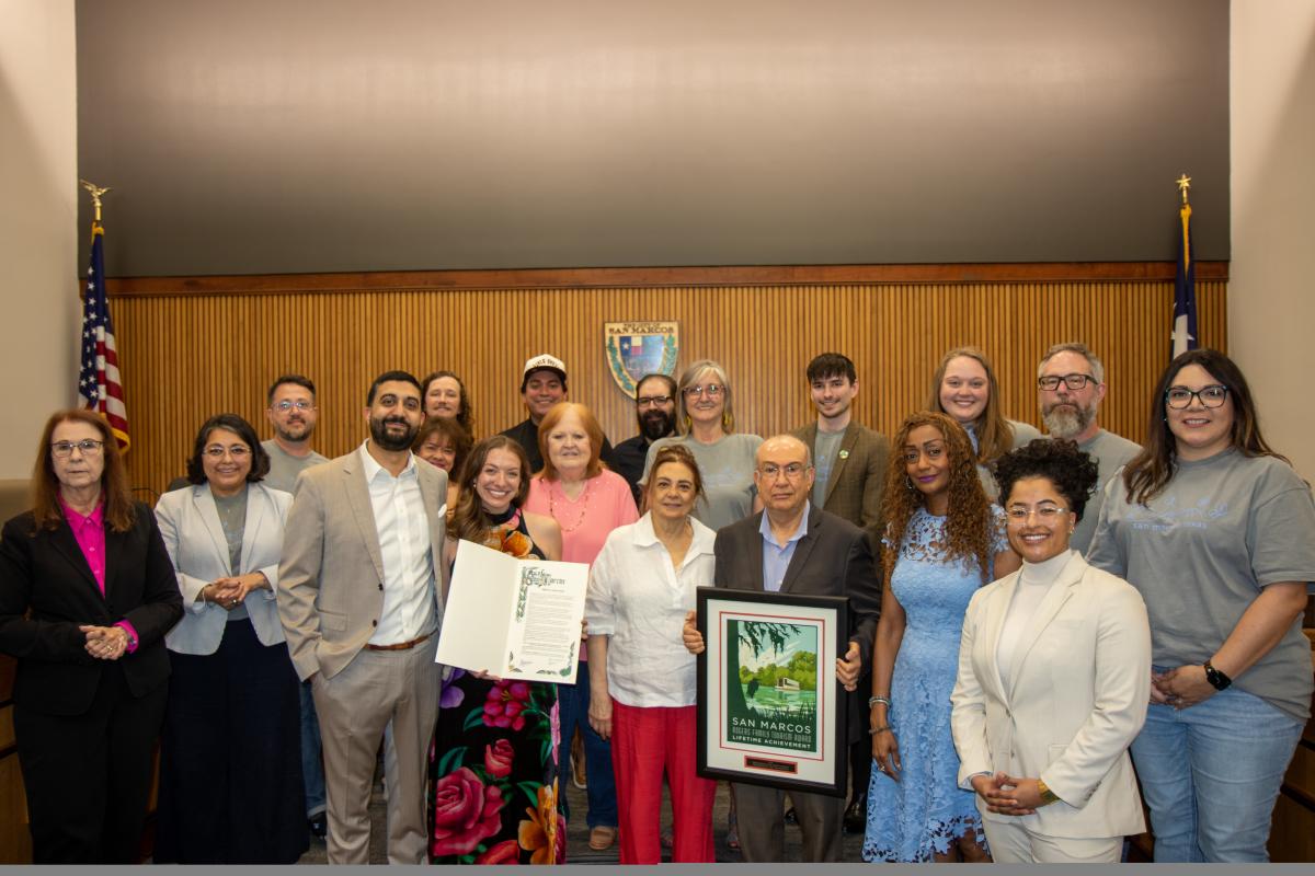 Mike and Omar Dawoud, along with their family and City of San Marcos staff, pose for a photo following the proclamation declaring them the 2026 Rogers Family Tourism Lifetime Achievement Award recipients.