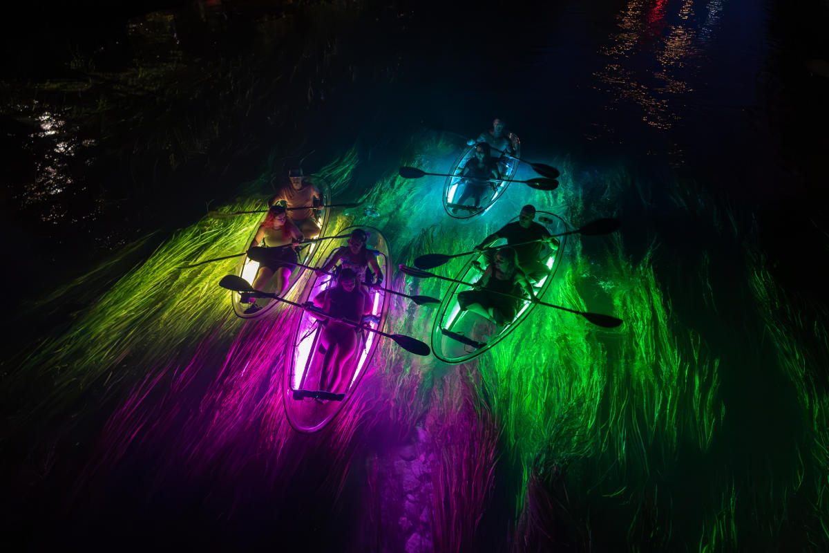 A group take a glow tour on the San Marcos River