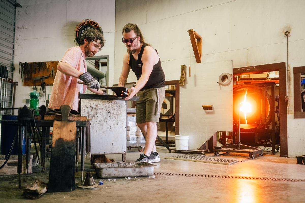 A man starts forming his own hand blown glass piece during a class at Wimberley Glassworks in San Marcos, Texas