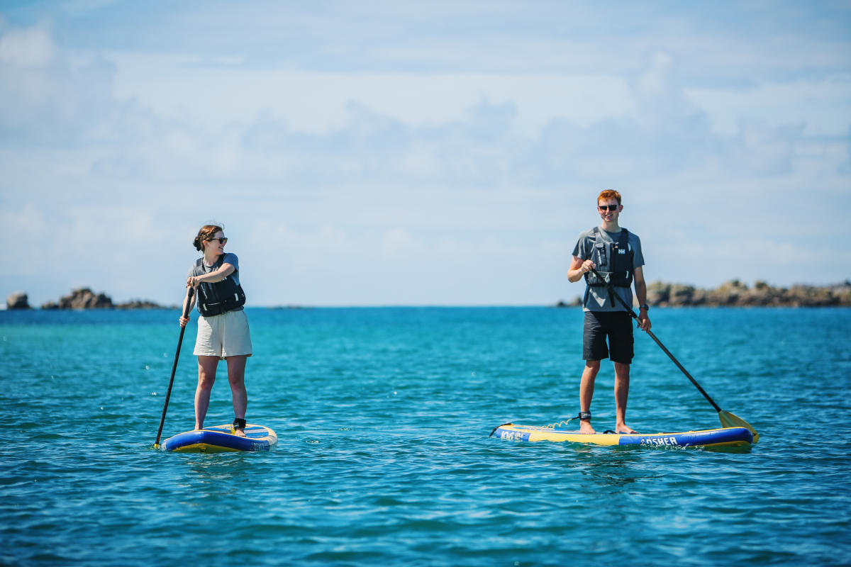 Two teenagers paddleboarding
