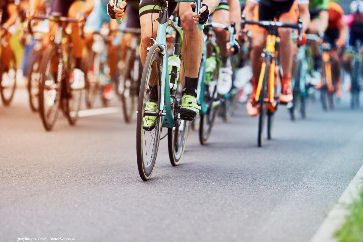 Cyclists racing surrounded by crowds