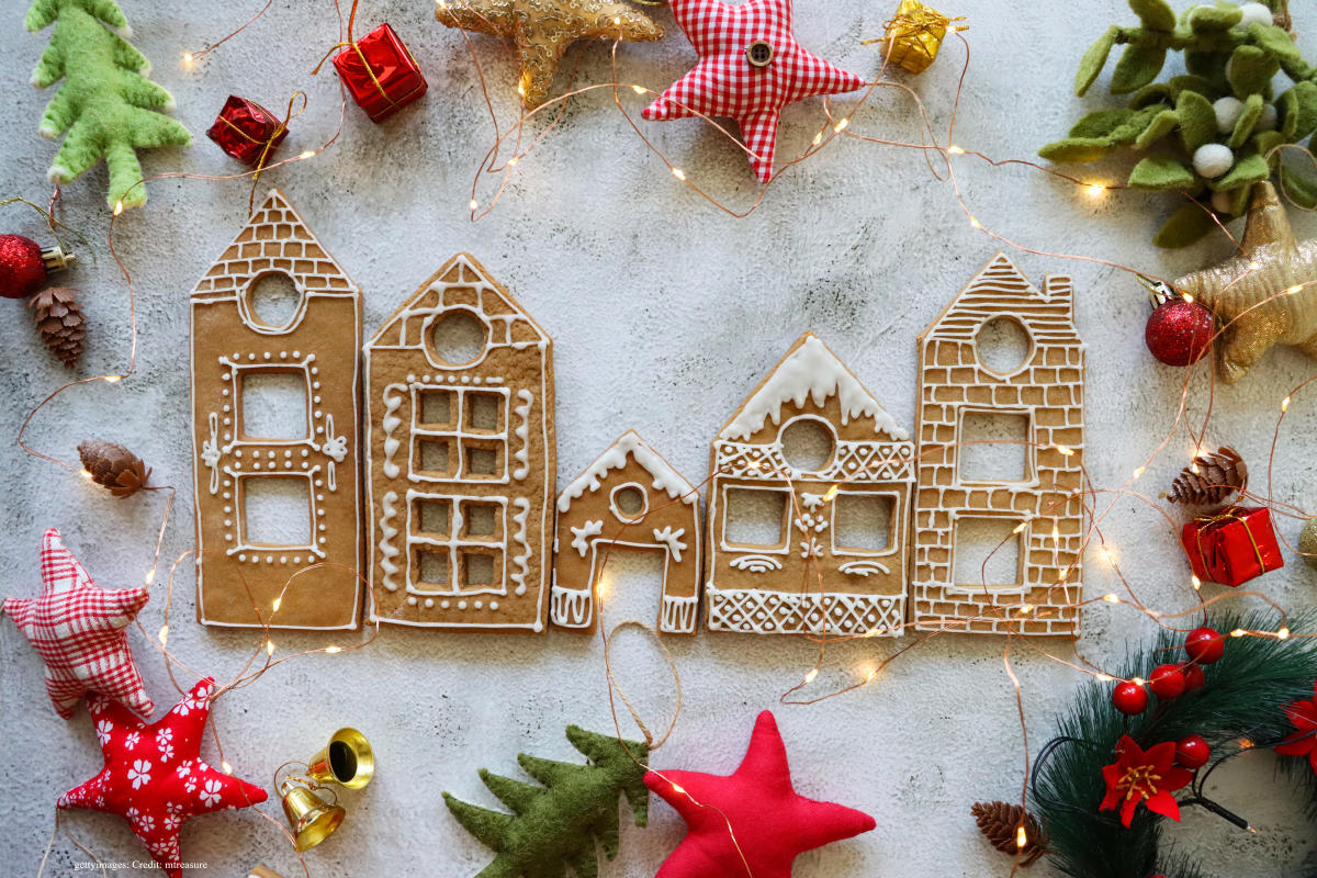Cut-outs of gingerbread buildings surrounded by Christmas decorations.