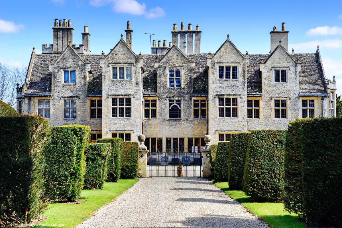 A tree-lined drive leading to a grand manor house in Oxfordshire, England