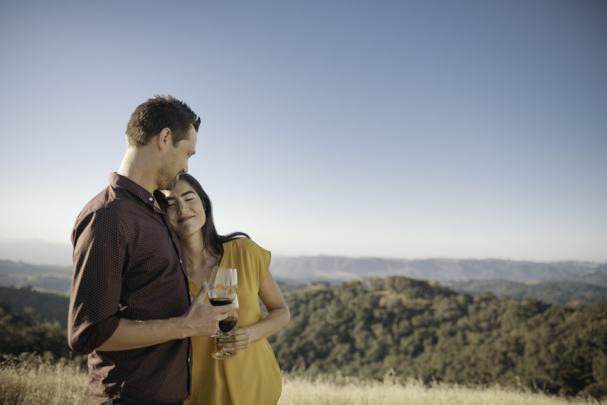 Man and Woman Hugging Outdoors While Drinking Wine in Paso Robles