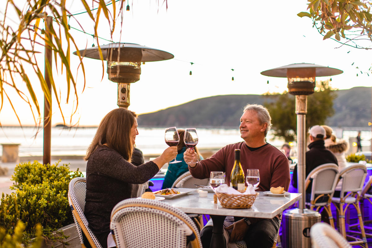 Couple raising wine glasses at dinner