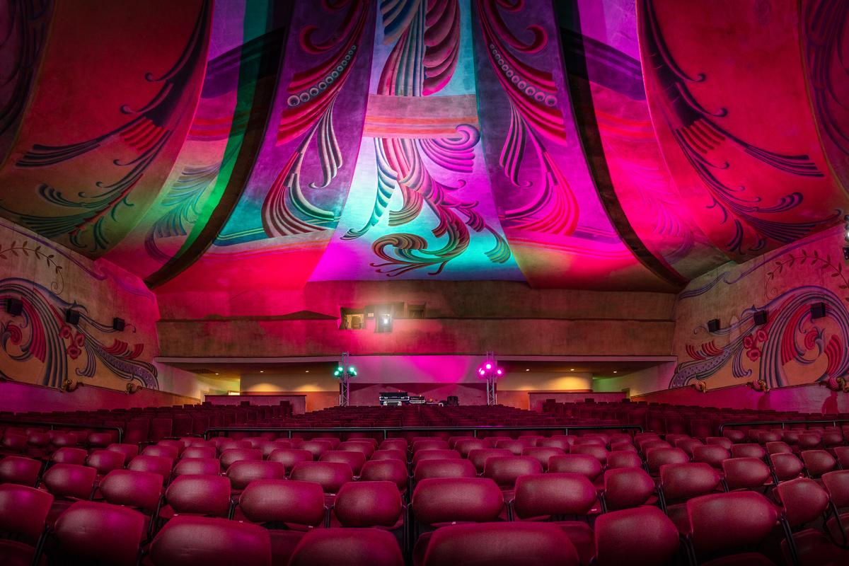 Interior of theater with red seats and colorful ceiling