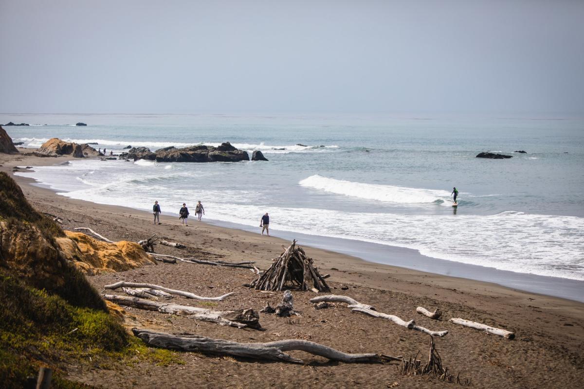 people walking down Moonstone Beach in Cambria