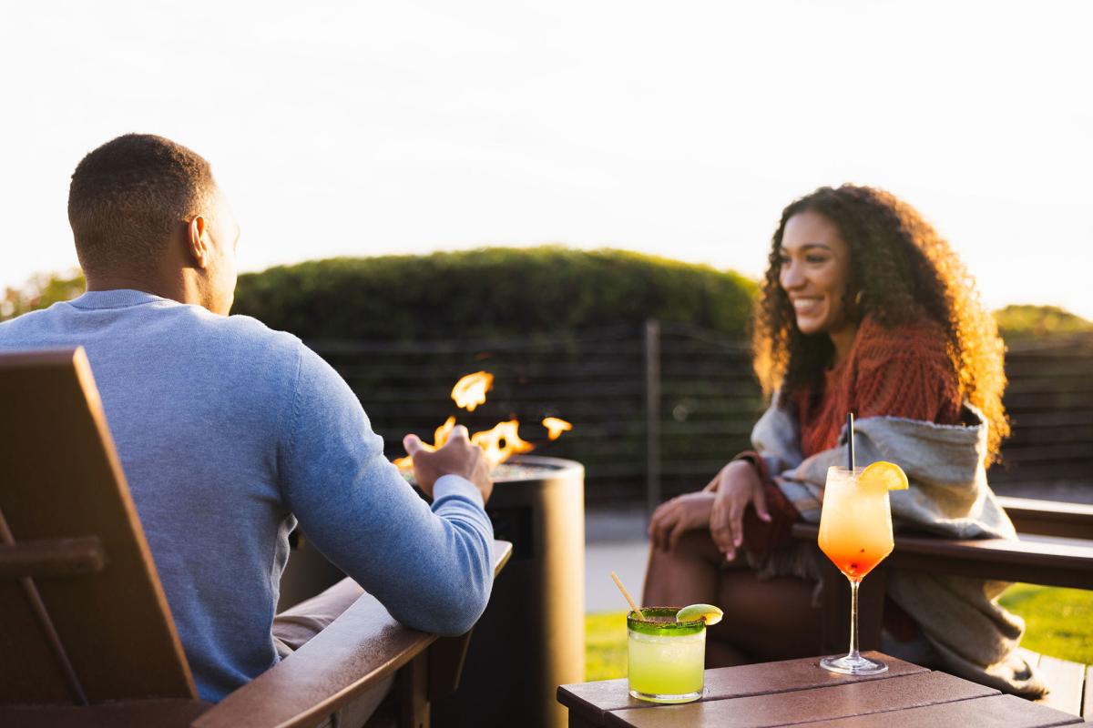 Couple enjoying drinks by bonfire