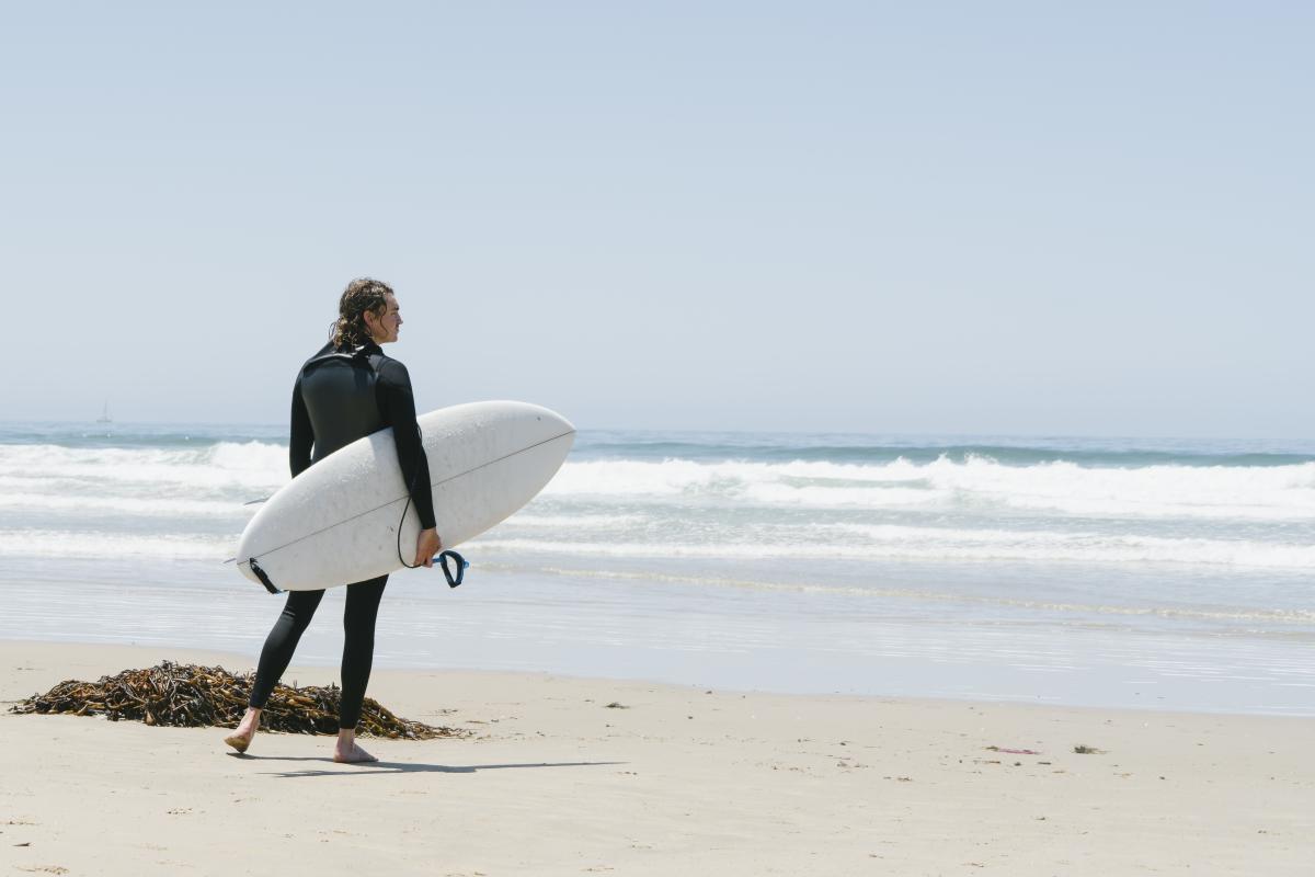 Surfer standing on the beach in SLO CAL