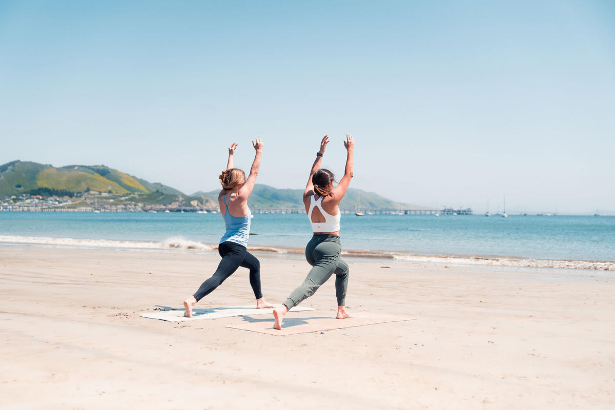 girls doing yoga on the beach
