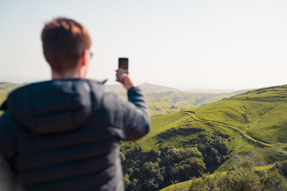 man taking picture of the rolling hills from Highway 46 west