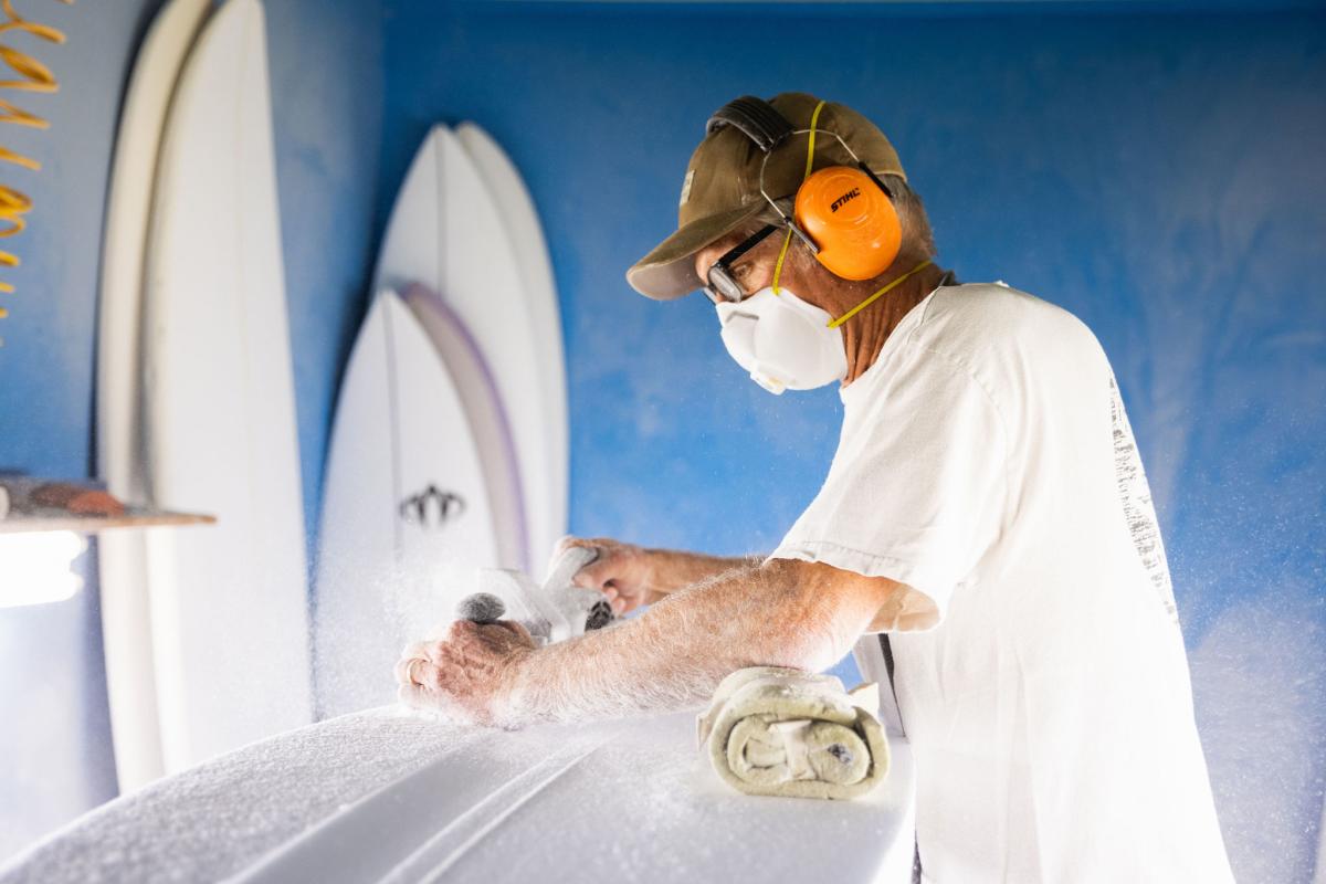 Surfboard shaper working on custom surfboard