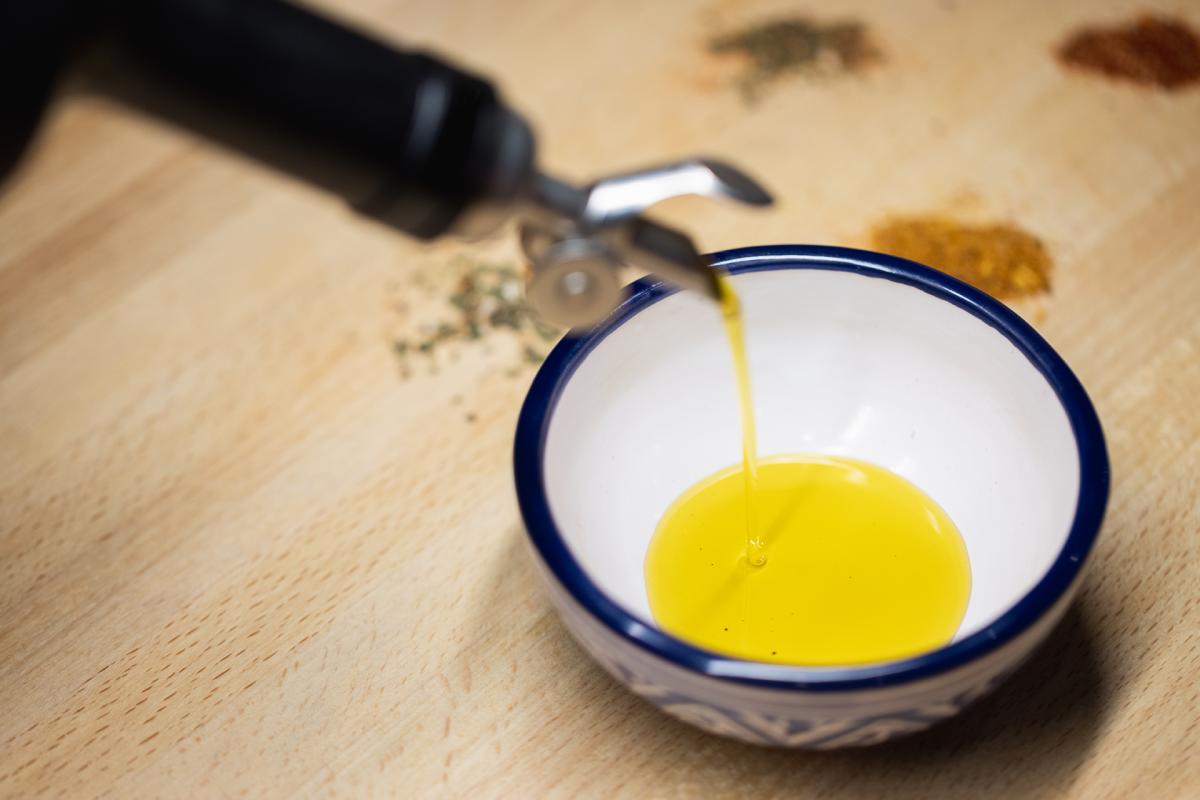 close up of olive oil being poured into a bowl