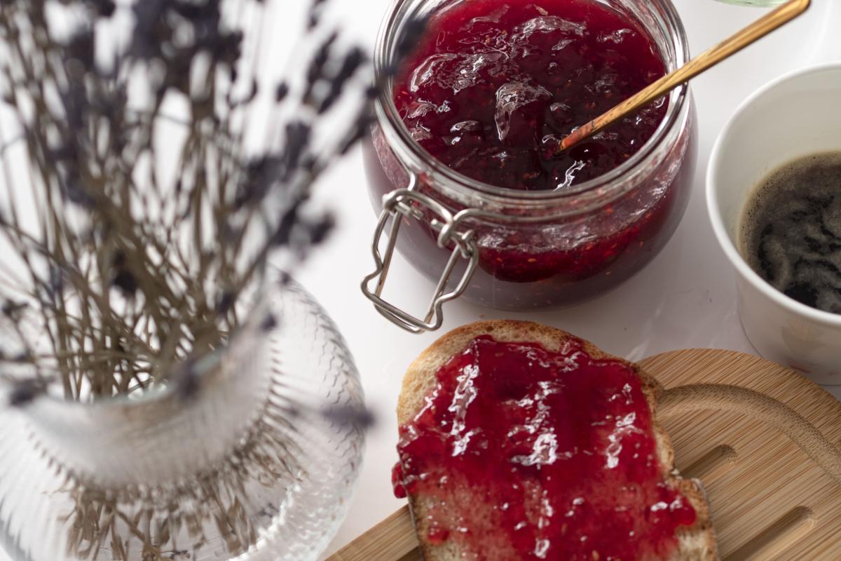 Jam on toast next to a jar filled with jam.